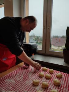 Uczestnik układa na obrusie uformowane ciasto na pączki