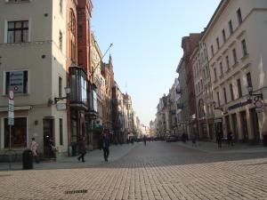 Widok z niskiej perspektywy na zabytkową ulicę Szeroką w Toruniu