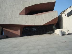 Nowoczesny nieregularny budynek w kolorze betonu i cegły zaburzona perspektywa