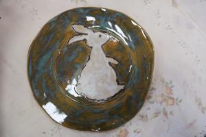 Gliniany talerz z wizerunkiem zająca, szkliwiony na zielono i ciemnoniebiesko