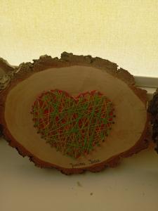 Serce na plastrze drewna wykonane techniką string-art