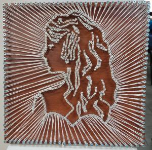 Praca wykonana na desce w technice string-art