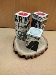Praca przedstawia trzy drewniane świeczniki wykonane w technice decoupage (motyw sztuki).